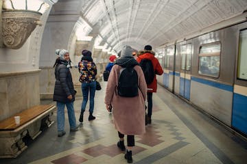 a group of people standing next to a train